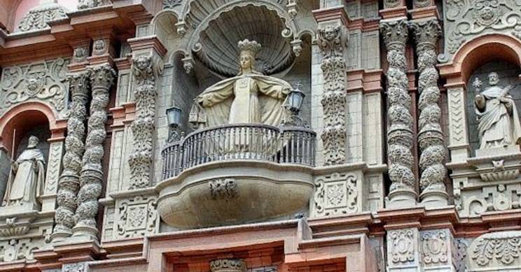 La imagen muestra la impresionante fachada de un edificio histórico en Lima, con hermosos detalles arquitectónicos y esculturas.