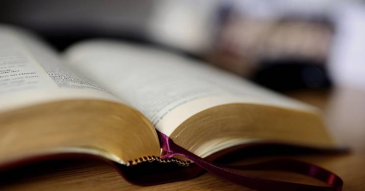 Un libro abierto sobre una mesa con una cinta de marcador visible.