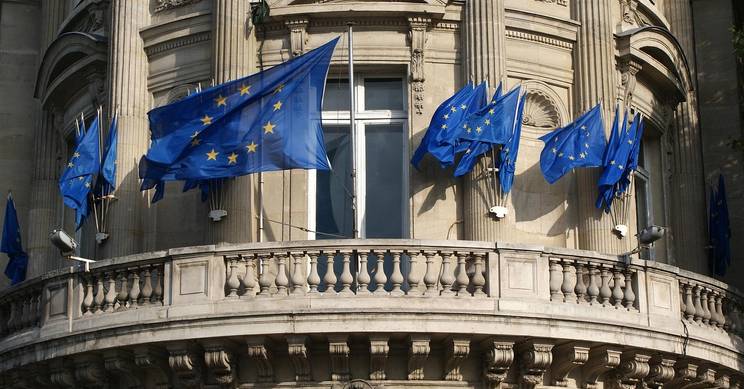 Edificio con banderas de la Unión Europea ondeando en su balcón.
