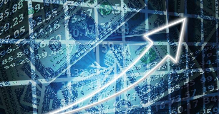 La imagen muestra billetes de dinero con un gráfico ascendente superpuesto.