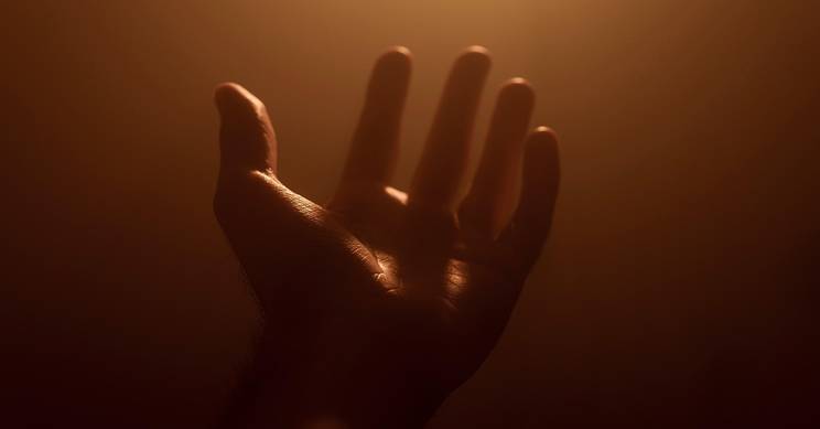 Una mano extendida en un ambiente iluminado con un tono cálido y suave.