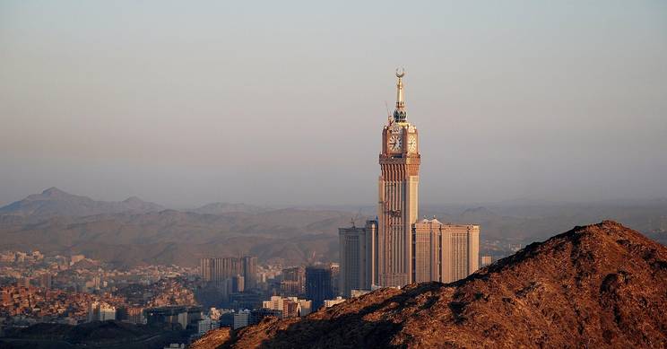 Una vista panorámica de una ciudad con un gran rascacielos y montañas al fondo.