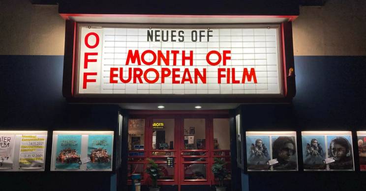 Fachada de un cine iluminado con el cartel del Mes del Cine Europeo.