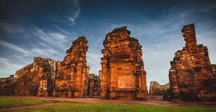 Ruinas antiguas iluminadas por un cielo estrellado.