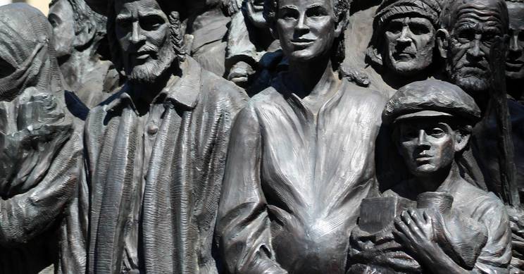 La imagen muestra un grupo de esculturas de personas en diferentes actitudes y vestimentas, representando una multitud en un contexto emocional.