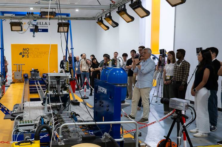 Un grupo de personas observa una presentación sobre tecnología en un laboratorio.
