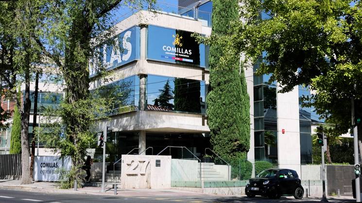 Edificio moderno con vegetación, que alberga la institución Comillas.