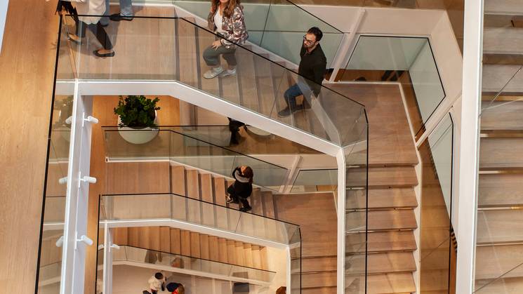 Vista panorámica de una escalera moderna con personas en varios niveles.