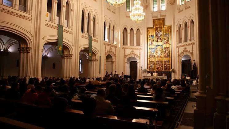 Interior de una iglesia con una gran cantidad de asistentes durante un servicio religioso.