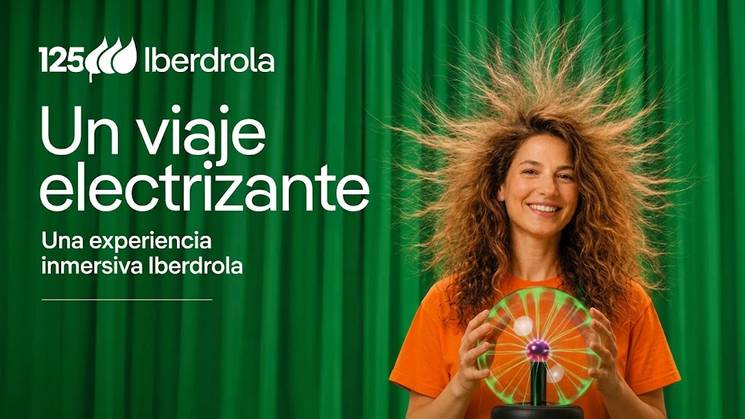 Una mujer sonriente con cabello rizado presenta una experiencia interactiva de Iberdrola.