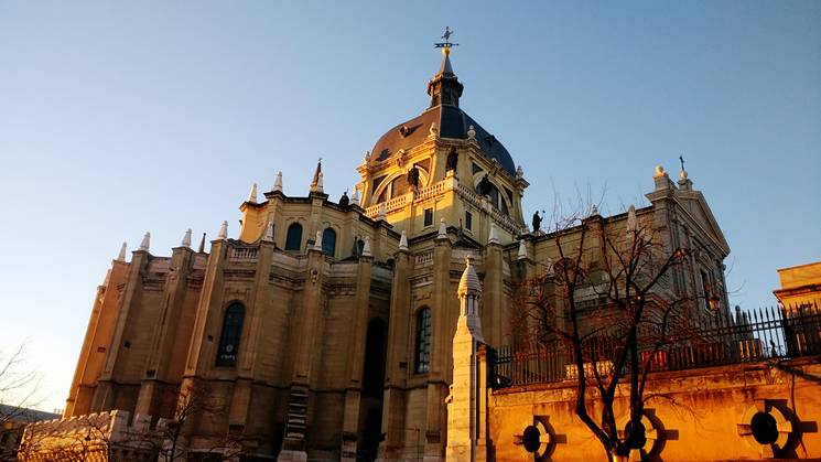 Una hermosa vista de una catedral con una cúpula prominente y un cielo despejado al atardecer.