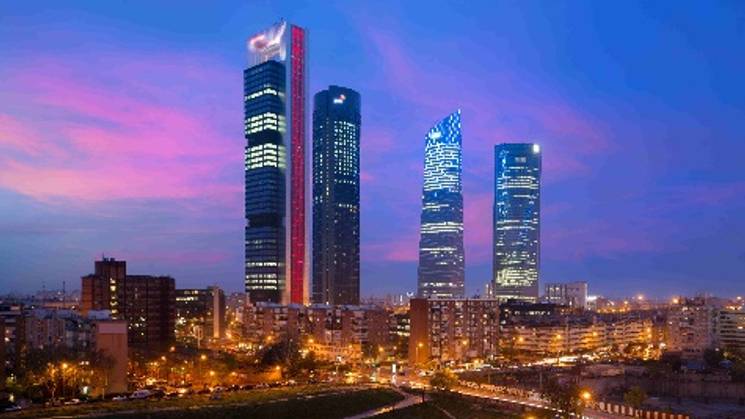 Una vista panorámica de los rascacielos de Madrid al anochecer.