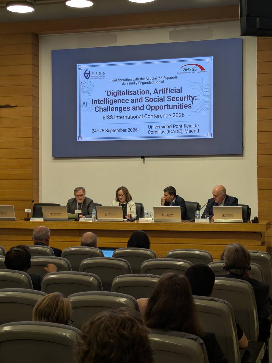 Una conferencia sobre digitalización, inteligencia artificial y seguridad social, con varios ponentes en una mesa frente a un público.