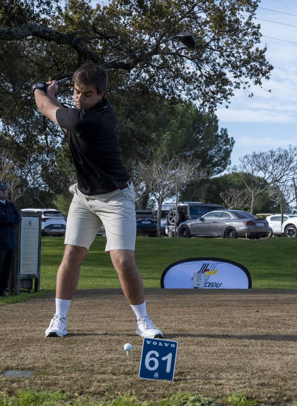 Un jugador de golf se prepara para realizar un golpe desde un tee en un campo de golf.