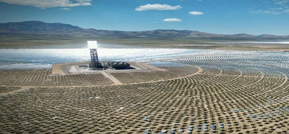 Vista aérea de un campo solar con paneles dispuestos en círculos alrededor de una torre de concentración solar.