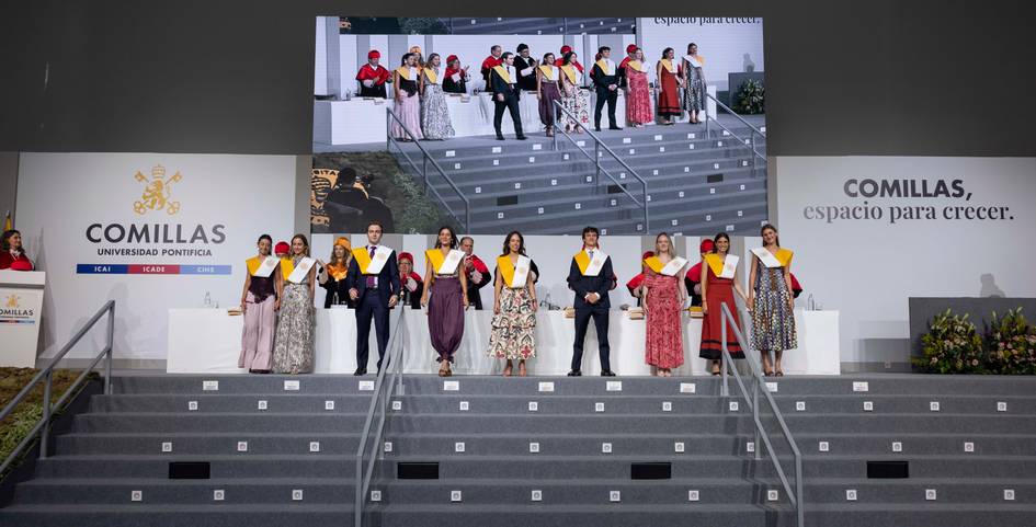 Celebración de graduación en la Universidad Pontificia Comillas con varios graduados en el escenario.