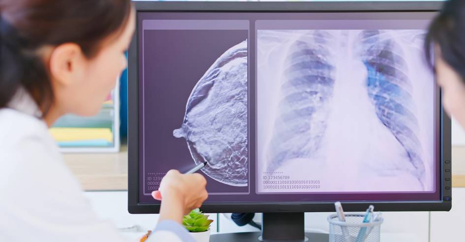Una profesional de la salud revisa radiografías en un monitor.