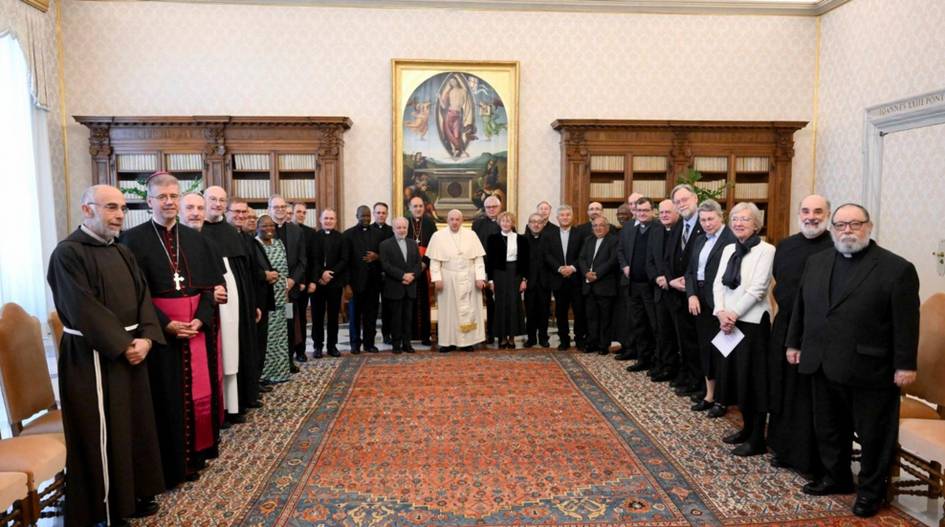 Una reunión de varios clérigos vestidos con ropas religiosas formales en una sala con una gran alfombra y una pintura en la pared.