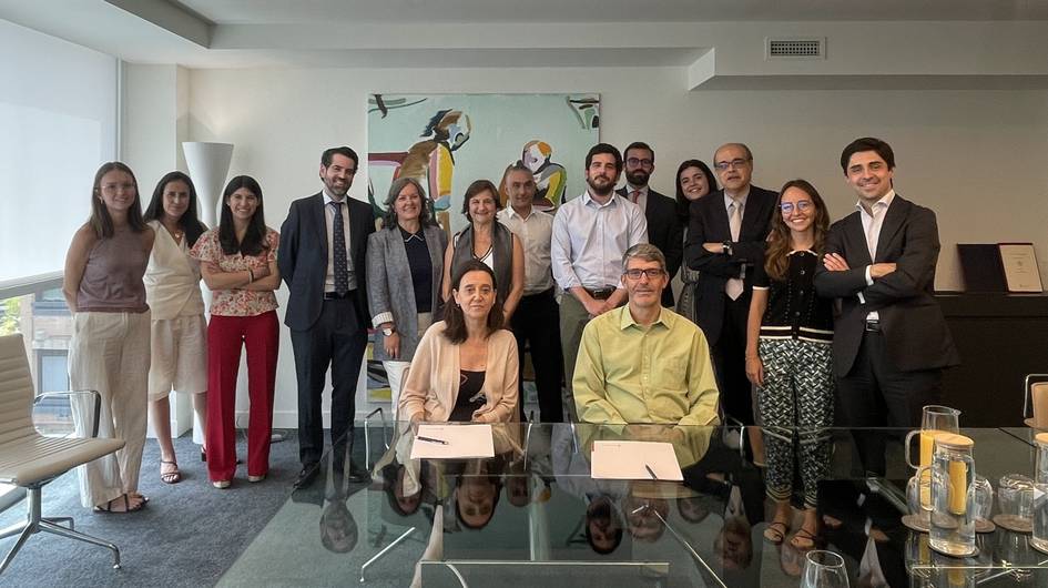 Un grupo de personas posando en una oficina moderna junto a una obra de arte.