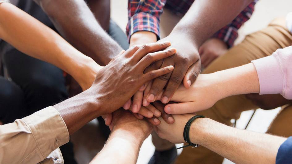 Un grupo de manos entrelazadas simbolizando unidad y colaboración.