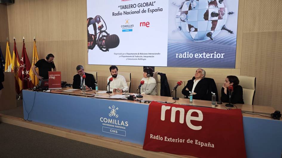 Fotografía de un evento en la Radio Nacional de España con varios panelistas en una mesa de conferencias.