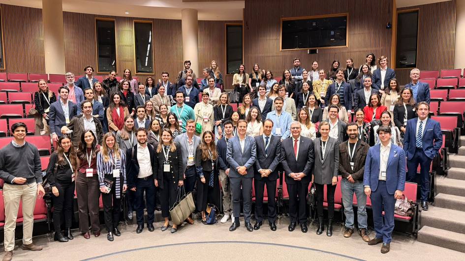 Un grupo grande de personas posando juntas en un auditorio.