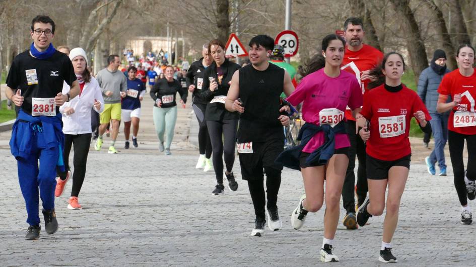 Un grupo de personas corriendo en una competición en un parque.