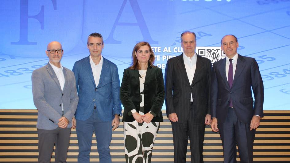 Cinco profesionales posan juntos en un evento frente a un fondo con texto y gráficos digitales.