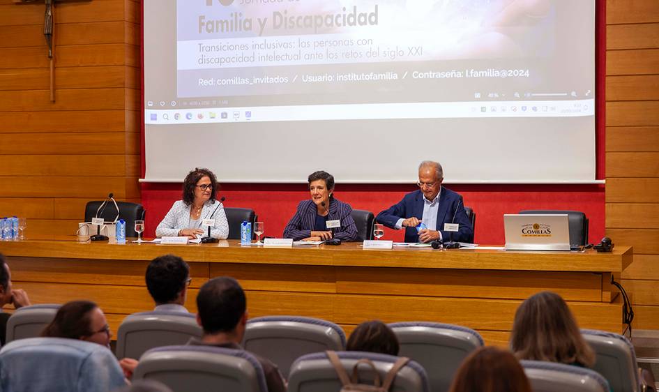 Three individuals are sitting at a panel in a conference room, addressing an audience about 'Family and Disability'.