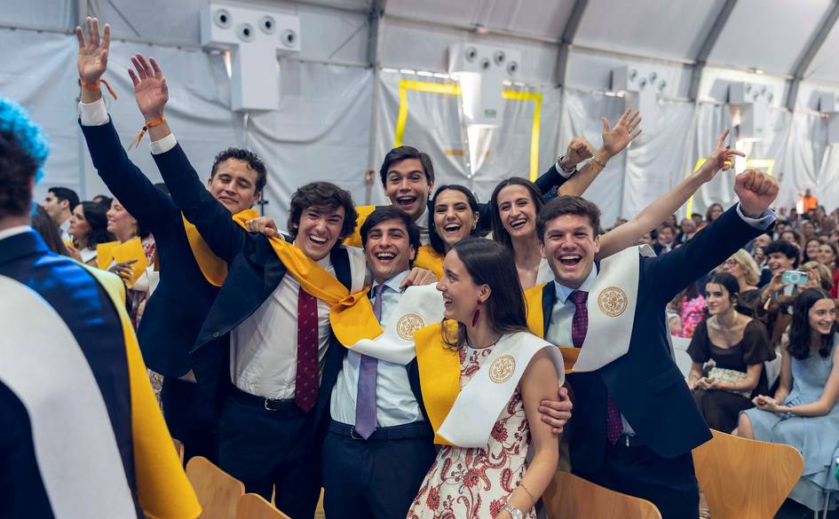 Un grupo de graduados sonríe y celebra juntos en una ceremonia de graduación.