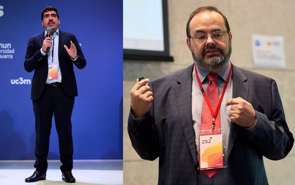 Dos hombres dan charlas en un evento, uno de pie hablando y el otro gesticulando frente a una pantalla.