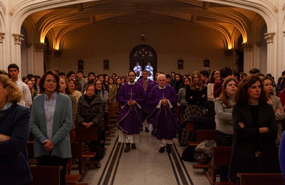 Una ceremonia religiosa con personas asistiendo en un lugar con iluminación tenue.