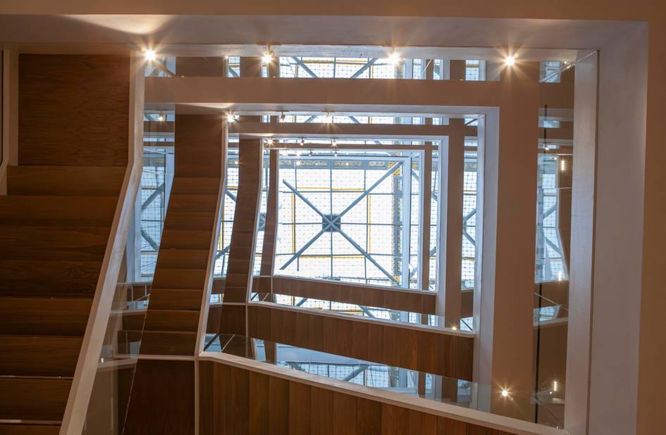 Una vista desde arriba de una escalera moderna con un diseño geométrico y luces brillantes.