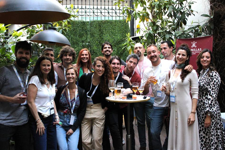 Un grupo de personas sonrientes se reúne en un ambiente festivo al aire libre, sosteniendo copas en un evento social.