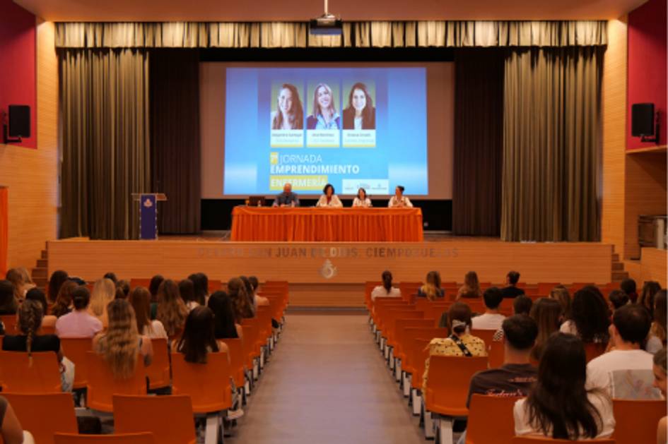 Una conferencia sobre emprendimiento con un panel de expertos frente a un público atento en un auditorio.