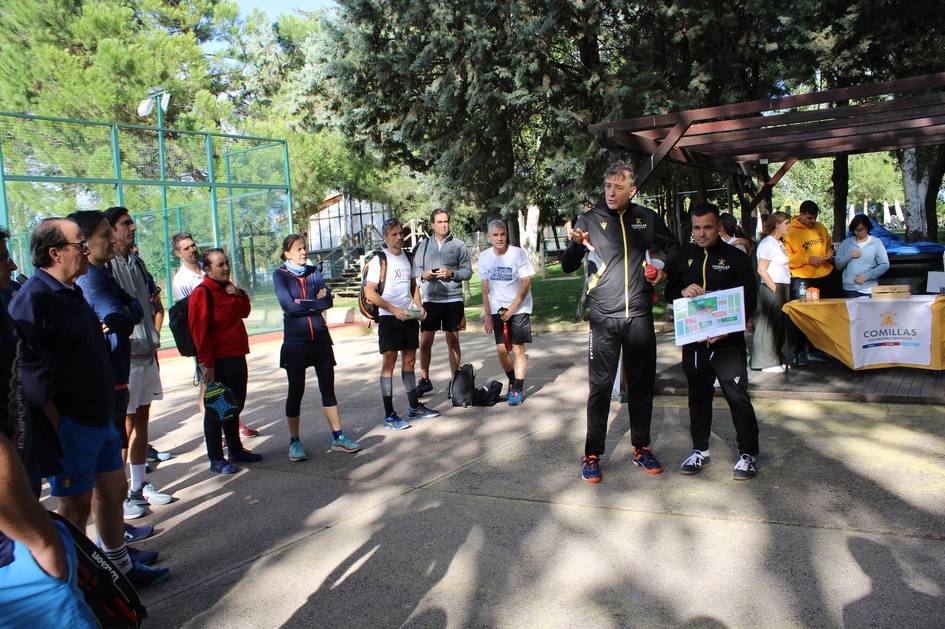 A group of people attending an outdoor fitness training session led by a trainer in a park.