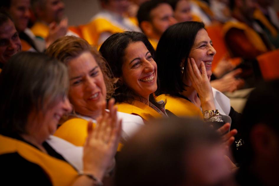 Un grupo de mujeres sonrientes aplauden durante un evento.