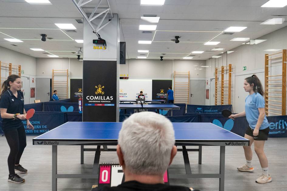 Dos jugadoras de tenis de mesa se preparan para un partido en una sala de deportes.