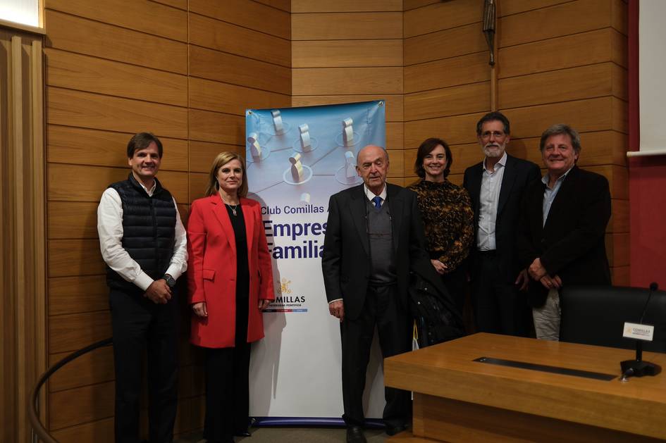 Un grupo de personas posando frente a un banner del Club Comillas sobre Empresas Familiares.