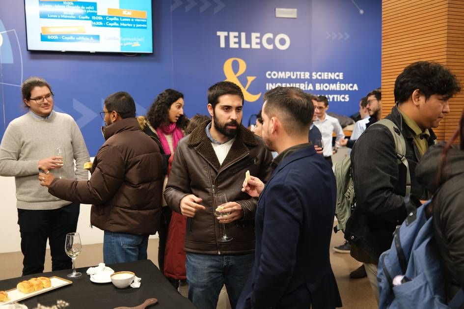 Un grupo de personas conversando en un evento relacionado con ciencia de la computación e ingeniería biomédica.