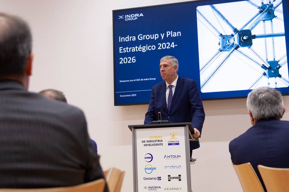 Un hombre presenta el Plan Estratégico 2024-2026 de Indra Group en un evento empresarial.
