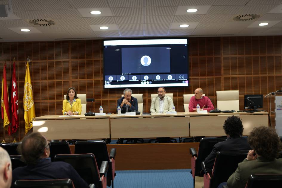 Una mesa redonda con varias personas sentadas frente a un auditorio, acompañadas de una presentación en pantalla.