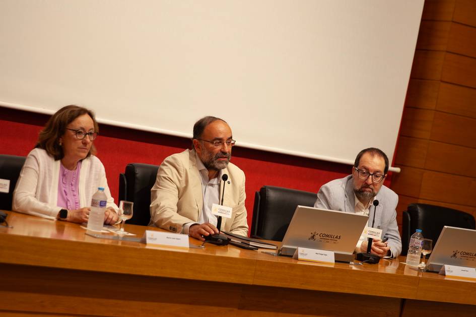 Tres personas están sentadas en una mesa durante un evento o conferencia.