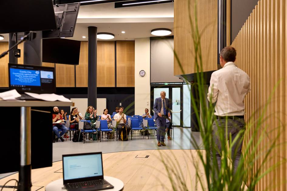 Un grupo de personas asiste a una presentación en un auditorio moderno.