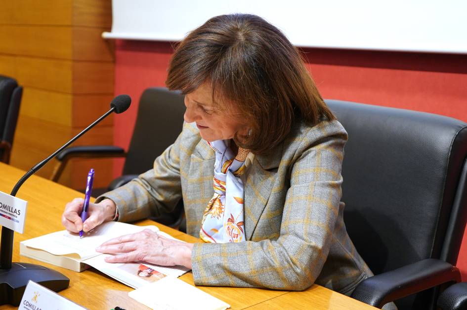 Una mujer está escribiendo en un libro durante un evento.