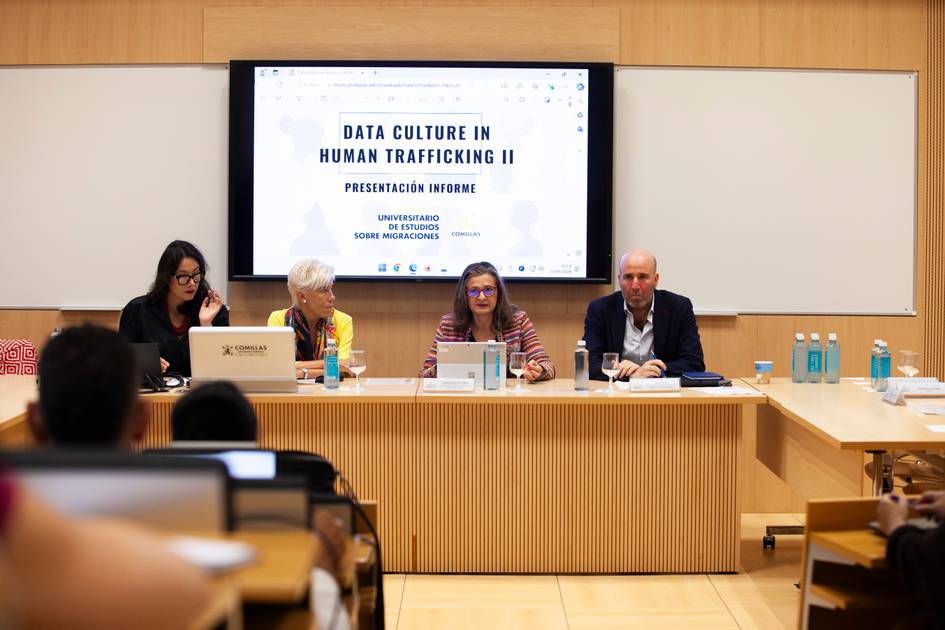 Four people are sitting at a table in a conference room, presenting or attending a session titled 'Data Culture in Human Trafficking II'.