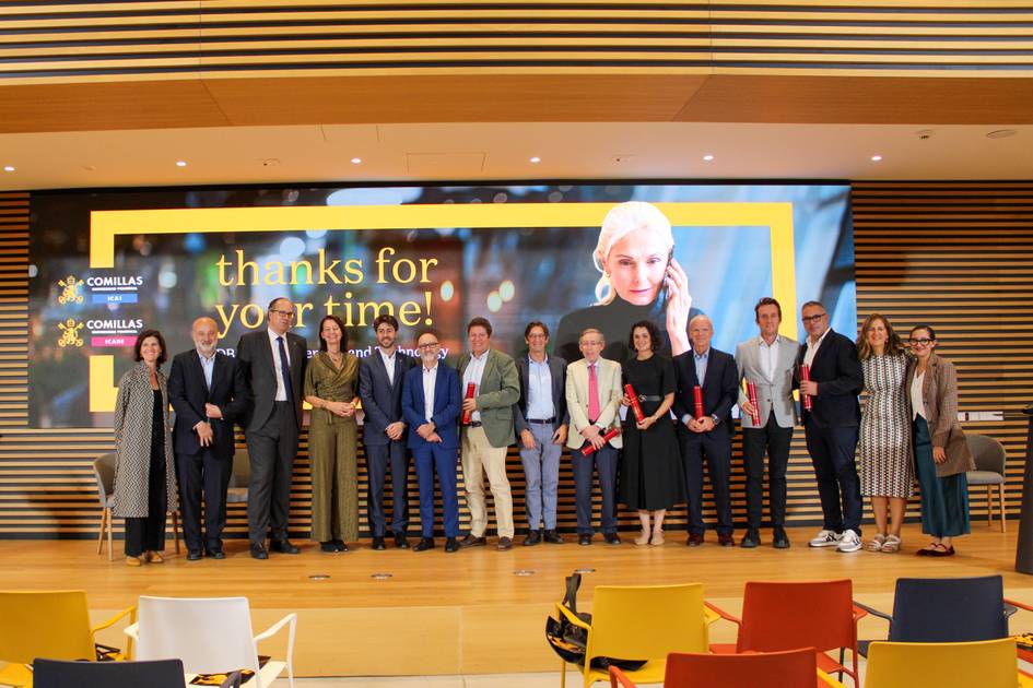 Un grupo de personas posando frente a una pantalla con un mensaje de agradecimiento en una sala moderna.