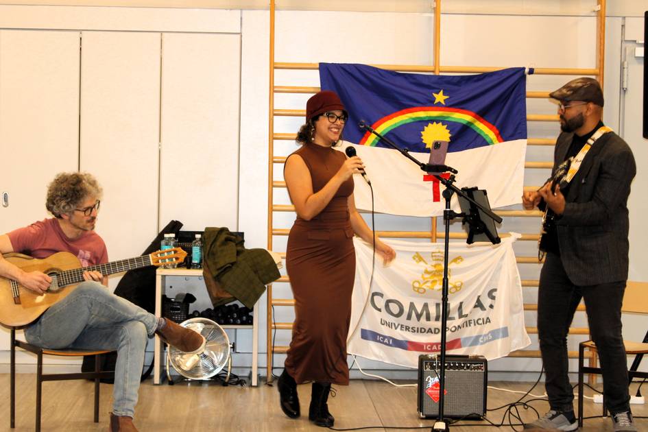 Un grupo musical se presenta en un escenario, con una cantante en el centro y dos músicos tocando la guitarra y el teclado.