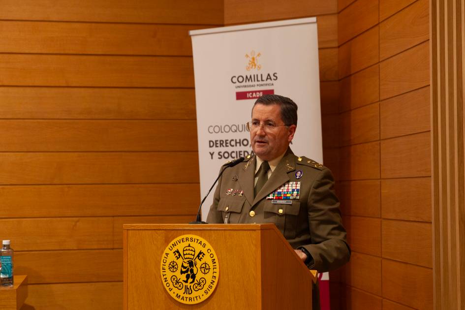 Un militar de alto rango habla en un evento académico frente a un podio con el logotipo de la universidad.