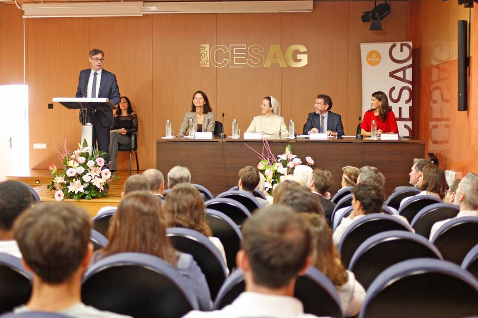 Una conferencia en un auditorio con una mesa de panelistas y un público atento.